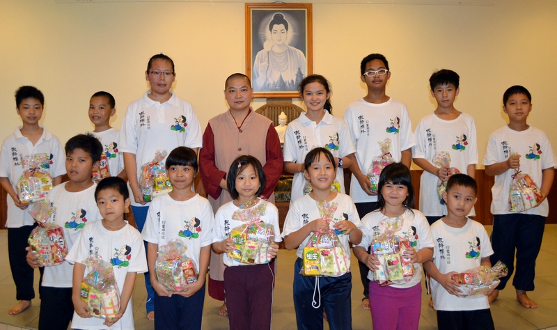 20131020 14名全程出席課程的同學、青少年愛心哥哥姐姐們都得到一份愛心禮物作為勉勵。圖為兒童班總負責人--禪孝法師與大家合影。